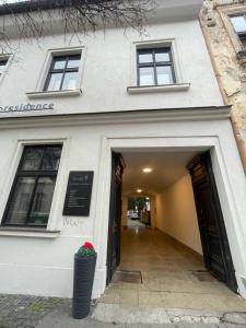 Farska apartman priamo v centre Nitry في نيترا: مبنى أبيض به رواق يؤدي إلى باب