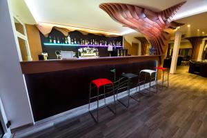 a bar with red stools in a restaurant at Villa 27 in Banská Bystrica