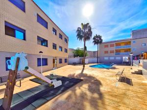 a playground in front of a building with a building at Apartamento con piscina en el Delta del Ebro in Sant Jaume d'Enveja