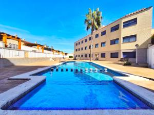 a swimming pool in front of a building at Apartamento con piscina en el Delta del Ebro in Sant Jaume d'Enveja