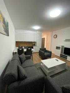 ein Wohnzimmer mit Sofa und Tisch in der Unterkunft L Apartaments in Peja + 3 Fotos