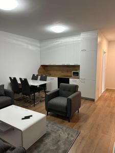 ein Wohnzimmer mit Tisch und Stühlen in der Unterkunft L Apartaments in Peja