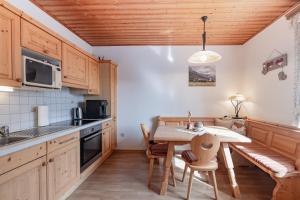 a kitchen with wooden cabinets and a table with chairs at Bio-Bergbauernhof Weger in Dellach