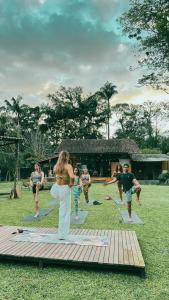a group of people doing yoga in a field at Drop House Hostel in Ubatuba