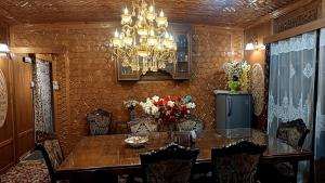 a dining room with a table and chairs and a chandelier at Goona palace houseboats in Srinagar