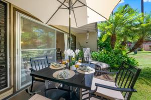a table and chairs with an umbrella on a patio at Maui Sands 1B in Honokowai