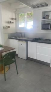 Zen and cozy escape between sea, mountain and river في بوانت-نوار: مطبخ بخزائن بيضاء وطاولة وكرسي أخضر