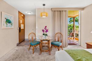 a dining room with a glass table and chairs at Maui Kaanapali Villas A414 in Kaanapali +17 photos