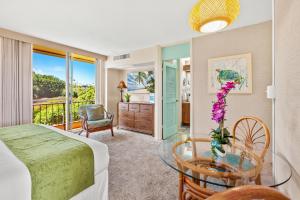 a bedroom with a bed and a glass table at Maui Kaanapali Villas A414 in Kaanapali