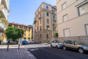 twee auto's geparkeerd aan de kant van een straat met gebouwen bij P&P House 38 Bilo 2 in Bergamo