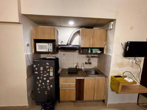 a small kitchen with a sink and a refrigerator at The night view in Noida