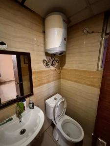 a bathroom with a white toilet and a sink at The night view in Noida +8 photos
