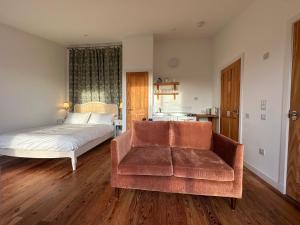 a bedroom with a bed and a couch and a chair at Speuran Mora in Saasaig