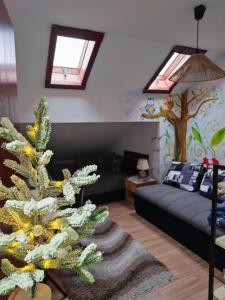 a living room with a couch and a christmas tree at JetNest in Niš