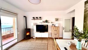 ein Wohnzimmer mit einem TV und einem großen Fenster in der Unterkunft Apartamento Mateuet in Calpe