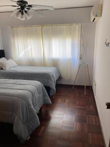 a bedroom with two beds and a ceiling fan at Apartamento en pleno centro in Salto