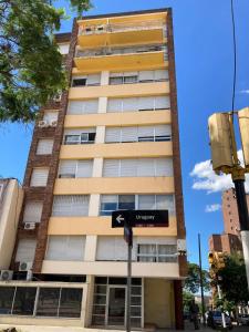 a tall building with a street sign in front of it at Apartamento en pleno centro in Salto +23 photos