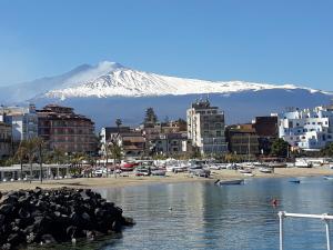 Sicily Etna Mareneve Taormina في فوميفريدو دي سيشيليا: اطلاله على مدينه فيها جبل مغطى بالثلوج