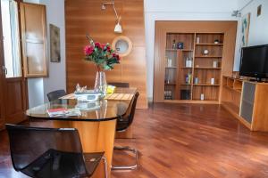 a living room with a table and chairs and a television at La finestra sulla piazza in Pisticci