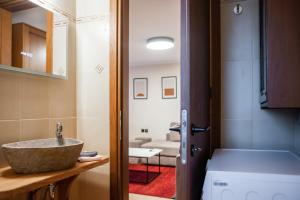 Tollmere Hospitality Λύχνος suite في ليفاديا: حمام به حوض غسيل بجوار غرفة +38 صورة