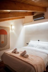 Tollmere Hospitality Λύχνος suite في ليفاديا: غرفة نوم بها سرير مع مناشف عليه