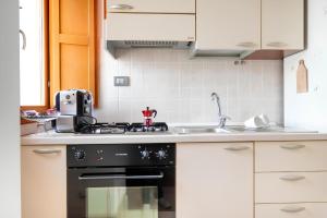 a kitchen with a black stove and a sink at La finestra sulla piazza in Pisticci