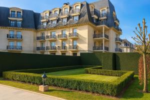 a large building with a garden in front of it at Appartement Premium 100 m2 avec Jardin Privé Plage et Centre à 400 m in Deauville
