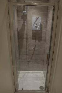 a shower with a glass door in a bathroom at Town Centre Apartments in Dewsbury