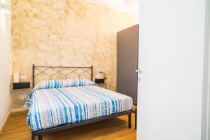 een slaapkamer met een bed met een gestreept dekbed bij P&P House 38 Bilo 2 in Bergamo