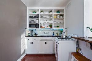 a white kitchen with white cabinets and a stove at 1BR Near UofA, Work Desk, Gem Show Friendly in Tucson