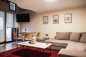 a living room with a couch and a table at Tollmere Hospitality Λύχνος suite in Livadeia