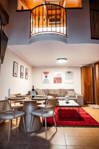 Tollmere Hospitality Λύχνος suite في ليفاديا: غرفة معيشة مع أريكة وطاولة وكراسي