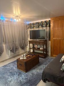 a living room with a tv and a coffee table at Petite maison au coeur des Hautes-Alpes in Aspres-sur-Buëch