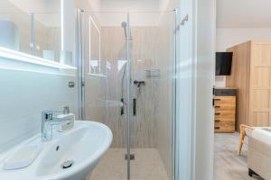 a bathroom with a sink and a glass shower at Sund Huus in Altefähr