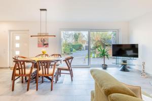 a dining room with a table and chairs and a tv at Sund Huus in Altefähr