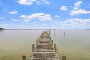a wooden dock in the middle of a body of water at Adventures on the Bay - Bayfront Escape, Private Dock, Large Deck, and Lake Views! in Hudgins