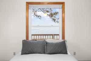 a bed in front of a large window at Adventures on the Bay - Bayfront Escape, Private Dock, Large Deck, and Lake Views! in Hudgins