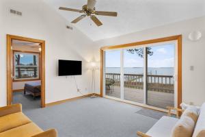 a living room with a ceiling fan and a tv at Adventures on the Bay - Bayfront Escape, Private Dock, Large Deck, and Lake Views! in Gwynn