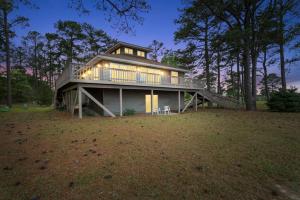 a large house with a deck on a field at Adventures on the Bay - Bayfront Escape, Private Dock, Large Deck, and Lake Views! in Gwynn