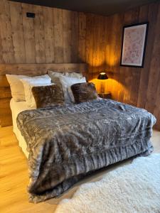 een slaapkamer met een groot bed en een deken bij L'Oxalis villa, l'Edelweiss in Bonnelles