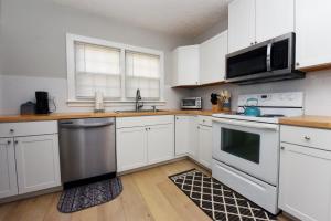 una cucina con armadietti bianchi ed elettrodomestici in acciaio inossidabile di The Copper Cottage on Main ad Abbeyville