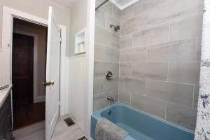 bagno con vasca blu in una stanza di The Copper Cottage on Main ad Abbeyville Altre 20 foto