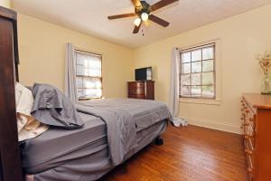 una camera da letto con un letto e un ventilatore a soffitto di The Copper Cottage on Main ad Abbeyville