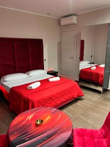 ein Hotelzimmer mit zwei Betten und einer roten Decke in der Unterkunft Hotel Iris in Varcaturo