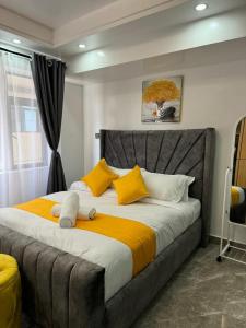 a bedroom with a large bed with yellow and white pillows at Jkia Airport 24 Hours Transit studio next 67hotel in Nairobi +191 photos