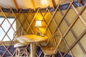 een tafel en stoelen in een kamer met een driehoekige muur bij Summerset Ridge - 100 Acre Reserve, River Access, and Endless Adventure! in Cullowhee