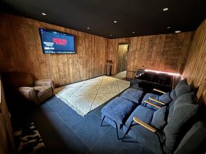 een woonkamer met banken en een flatscreen-tv bij L'Oxalis villa, l'Edelweiss in Bonnelles