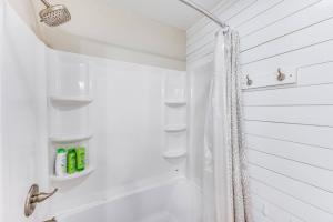 een witte badkamer met een douchegordijn en een bad bij Redwing Farm Cottage - Mountain Views and Firepit! in Goode +44 foto's