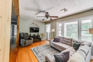 een woonkamer met een bank en een plafondventilator bij Redwing Farm Cottage - Mountain Views and Firepit! in Goode