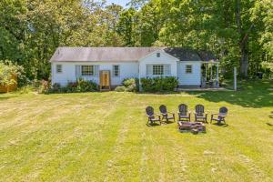 een tuin met drie stoelen en een huis bij Redwing Farm Cottage - Mountain Views and Firepit! in Goode